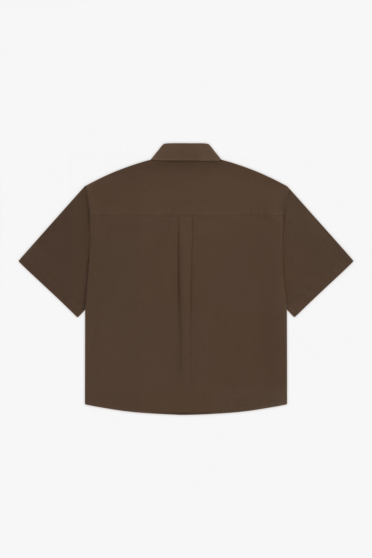 The Calter Volume Shirt, shown from the back in brown cotton poplin, features an oversized boxy fit, short sleeves, and a single central pleat, displayed against a white background.