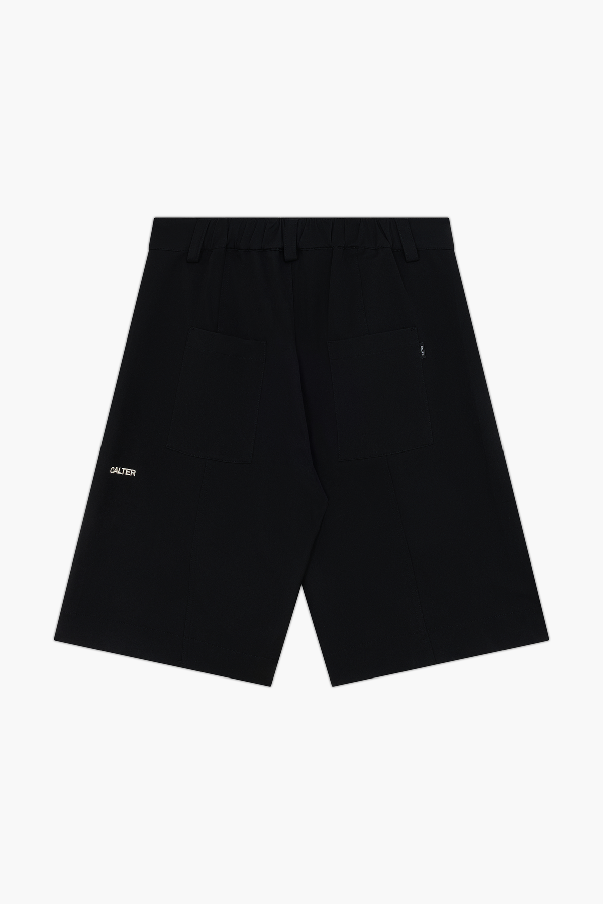 Black Pleated Shorts, back view, showing the gathered waistband, rear patch pockets and white CALTER embroidery.