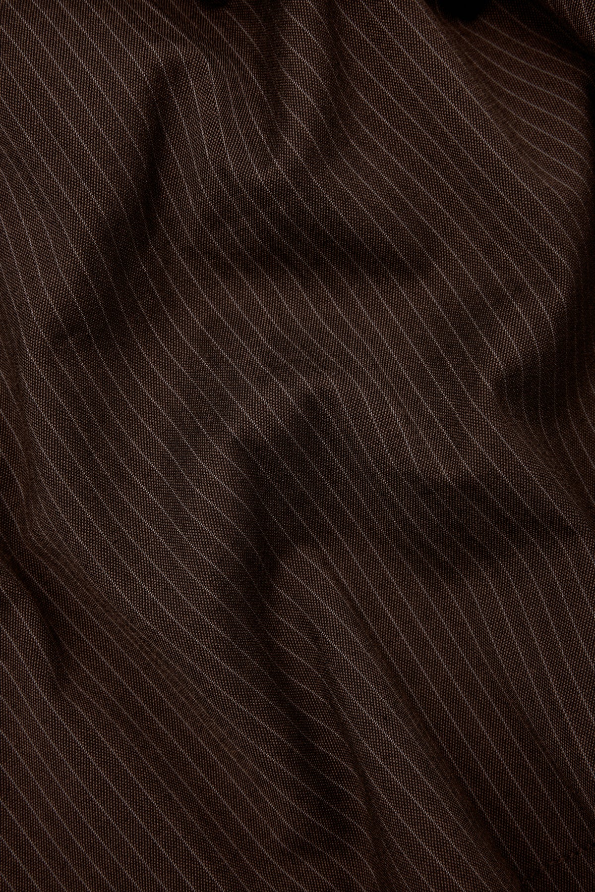 Close-up of the fine pinstripe and fabric texture of Brown Stripe Pleated Shorts.