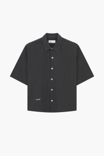 Charcoal Volume Shirt, front view, showing the short sleeves, chest patch pocket and contrast front-hem embroidery.