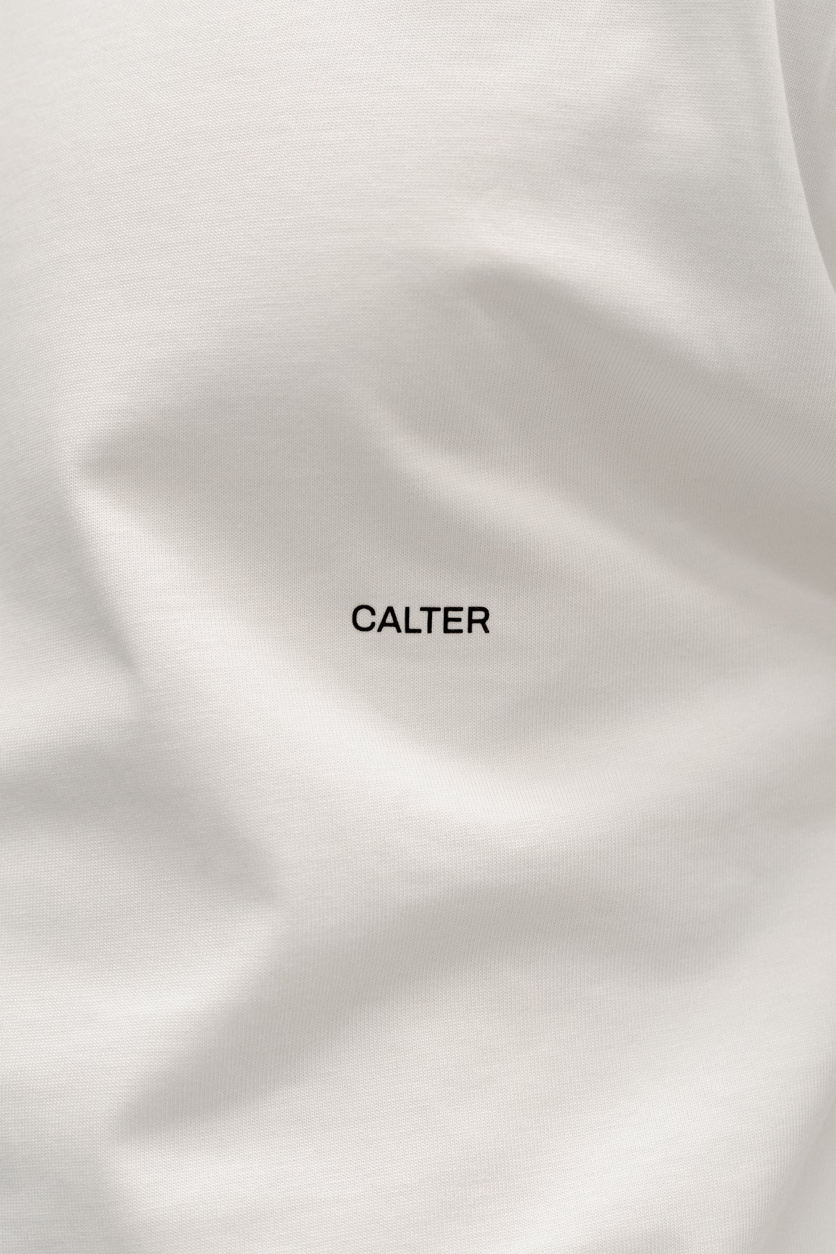 Close-up of the black CALTER chest print on the Off-White Stamp Tee.