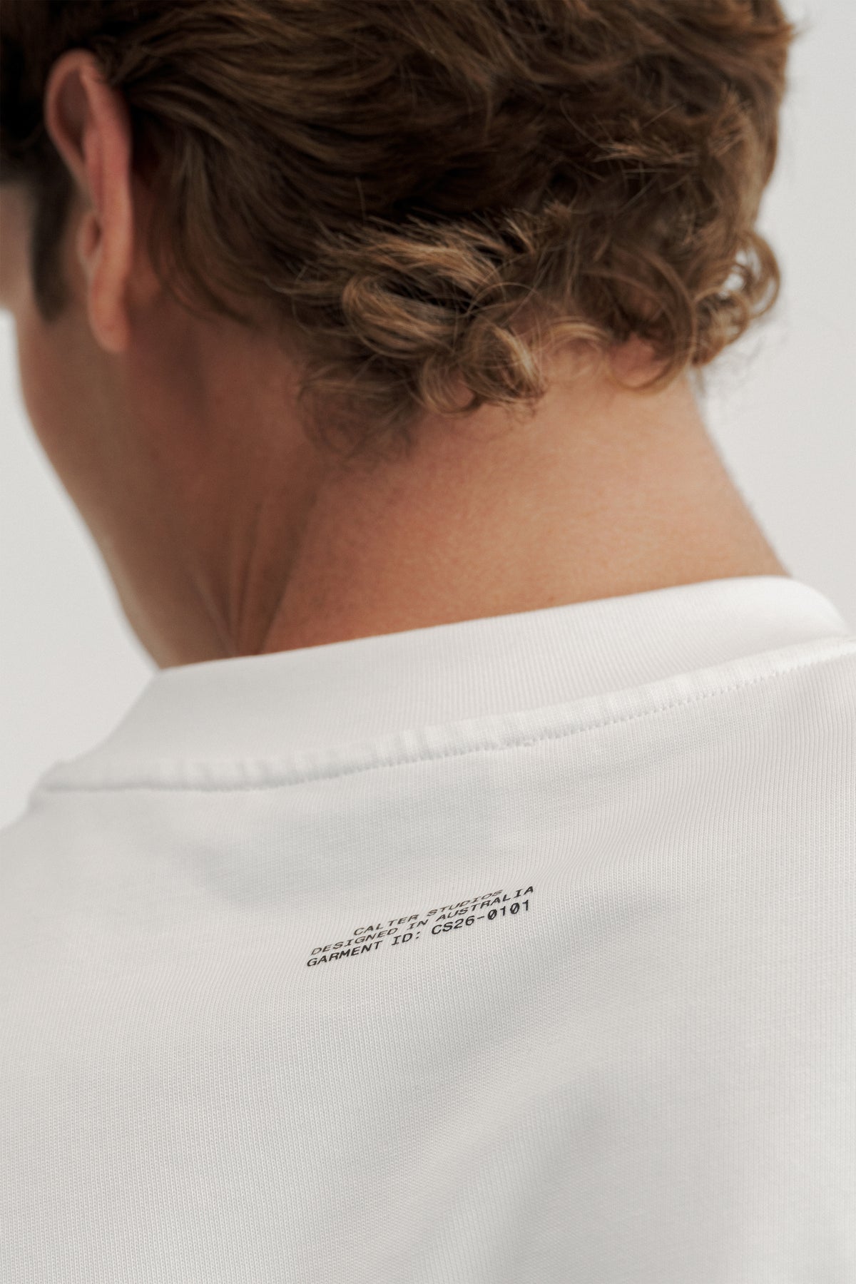 Close-up of the black garment ID print below the rear neckline of the Off-White Stamp Tee.
