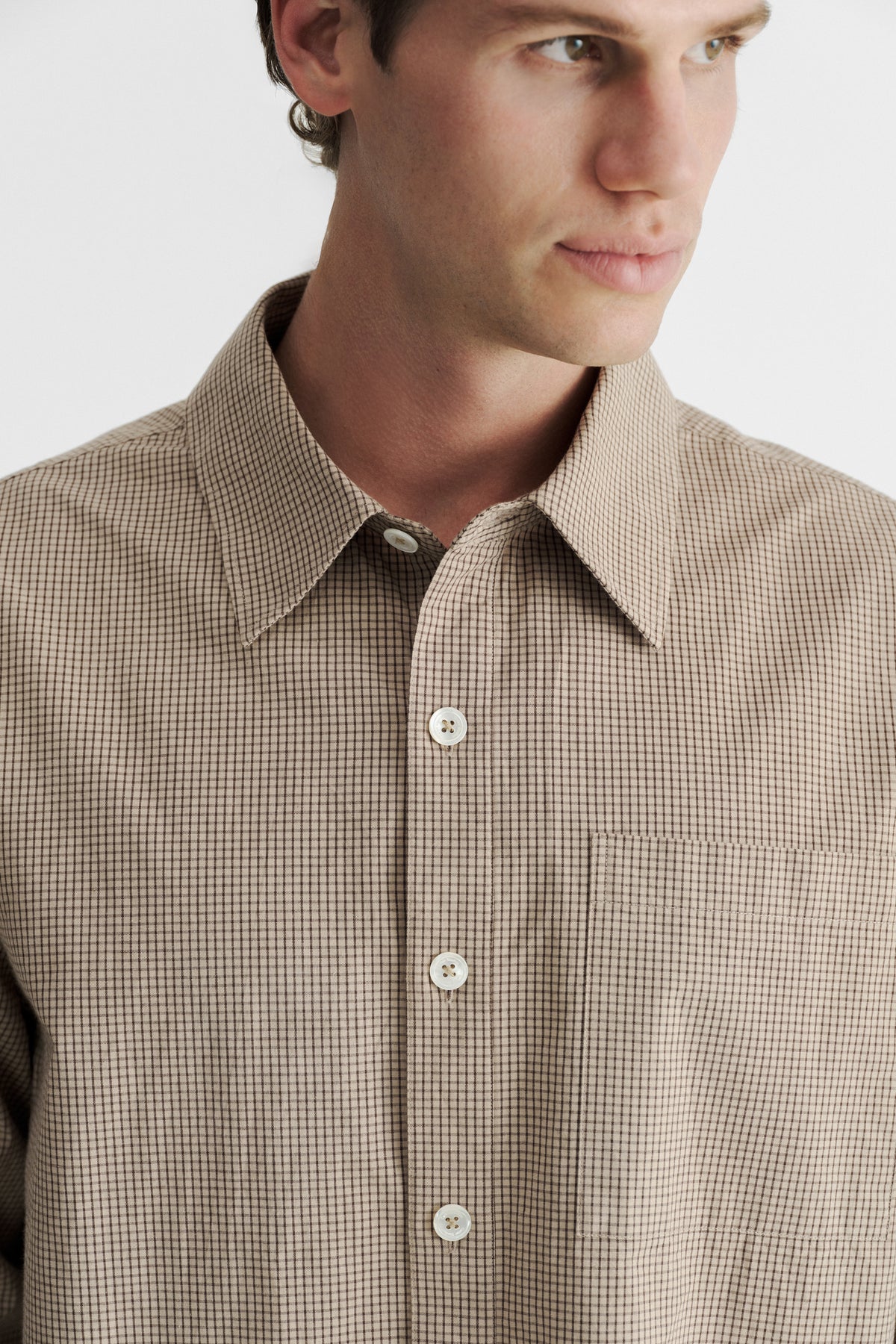 Close-up of the collar, light buttons and chest pocket on the Sand Microcheck Studio Shirt.
