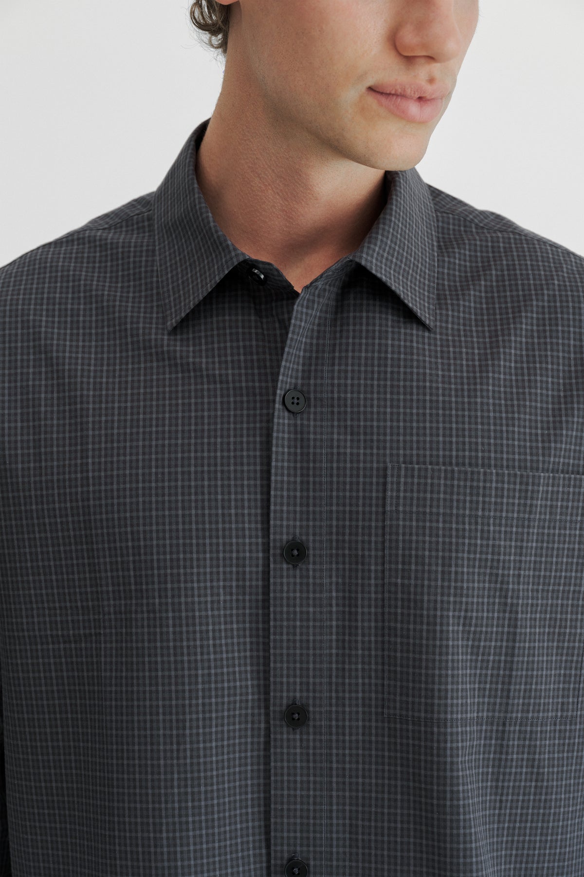 Close-up of the collar, black buttons and chest pocket on the Slate Microcheck Studio Shirt.