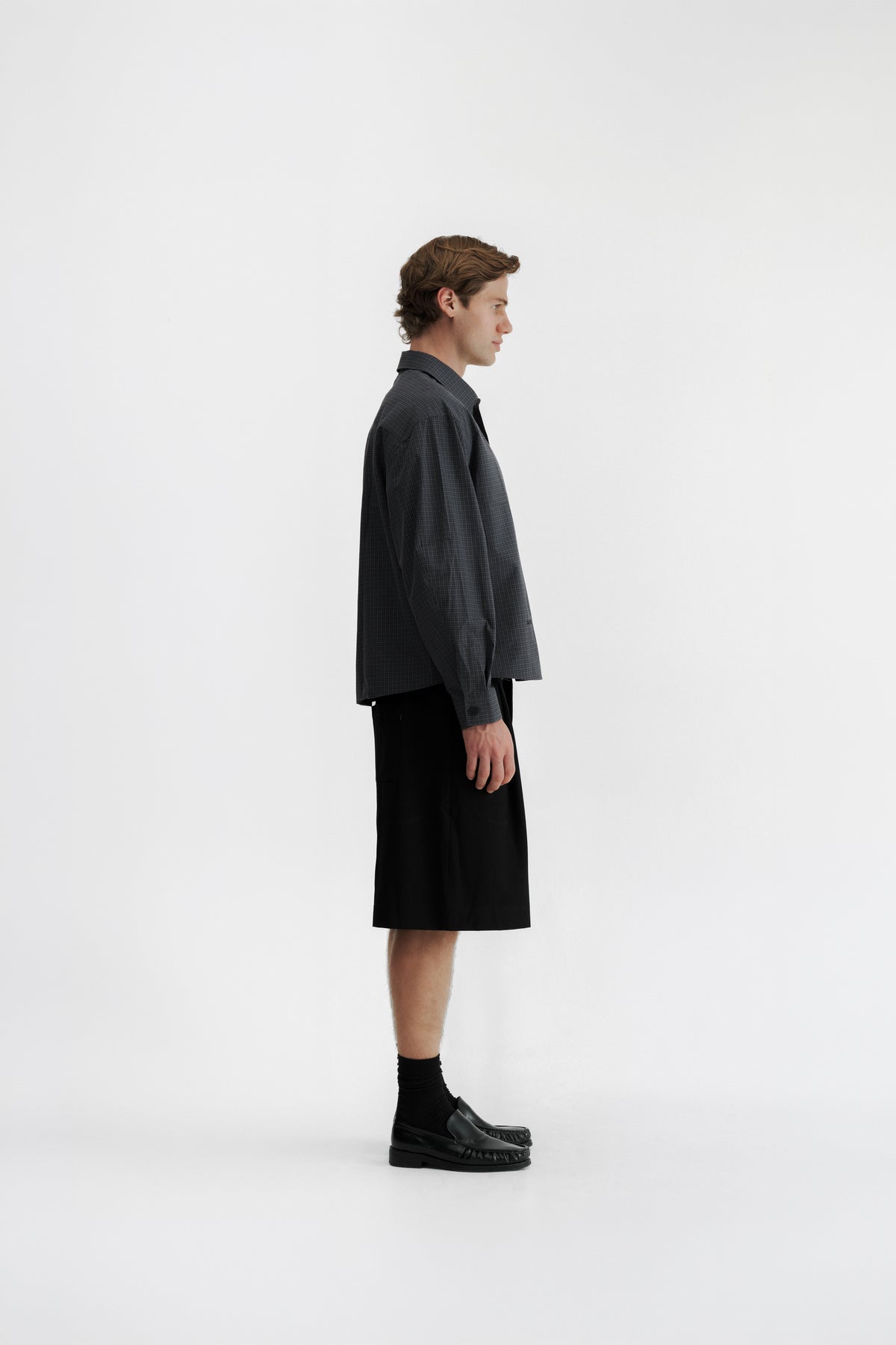 Side view of a model wearing the Slate Microcheck Studio Shirt, showing the wide sleeve and shortened body.