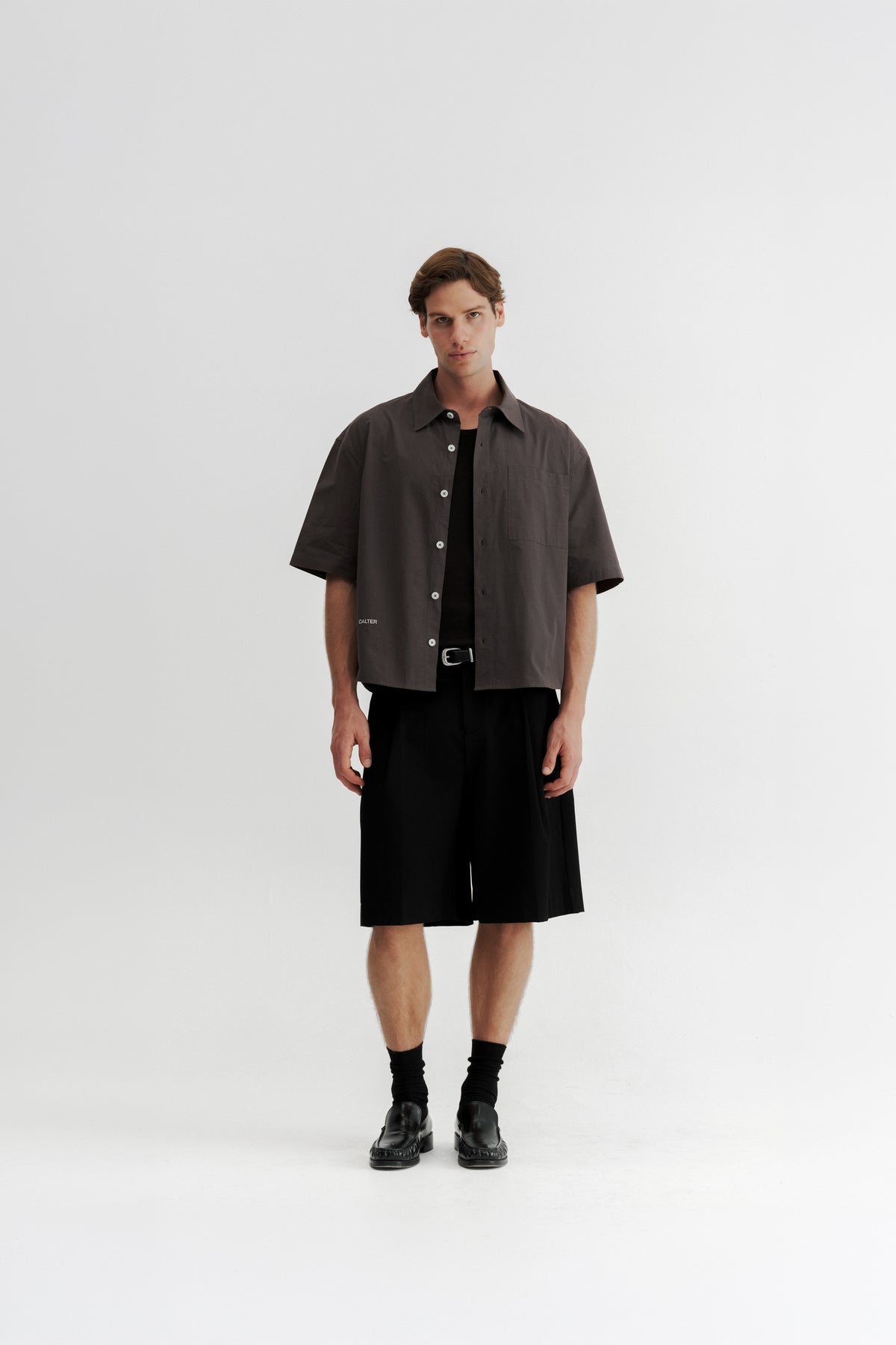 Full-length front view of a model wearing the Charcoal Volume Shirt open over a black tank top.